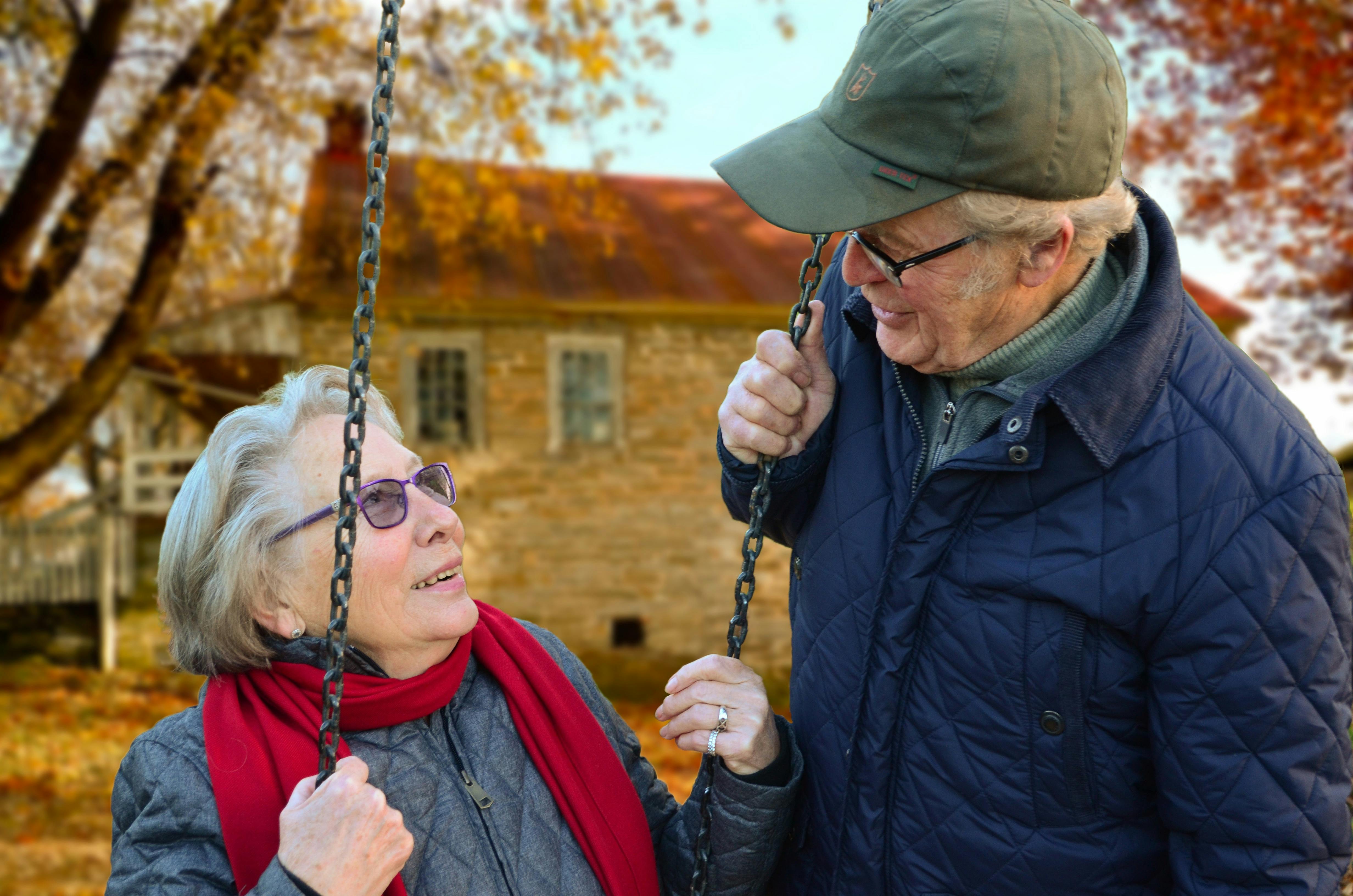 old woman on a swing whilst man looks at her