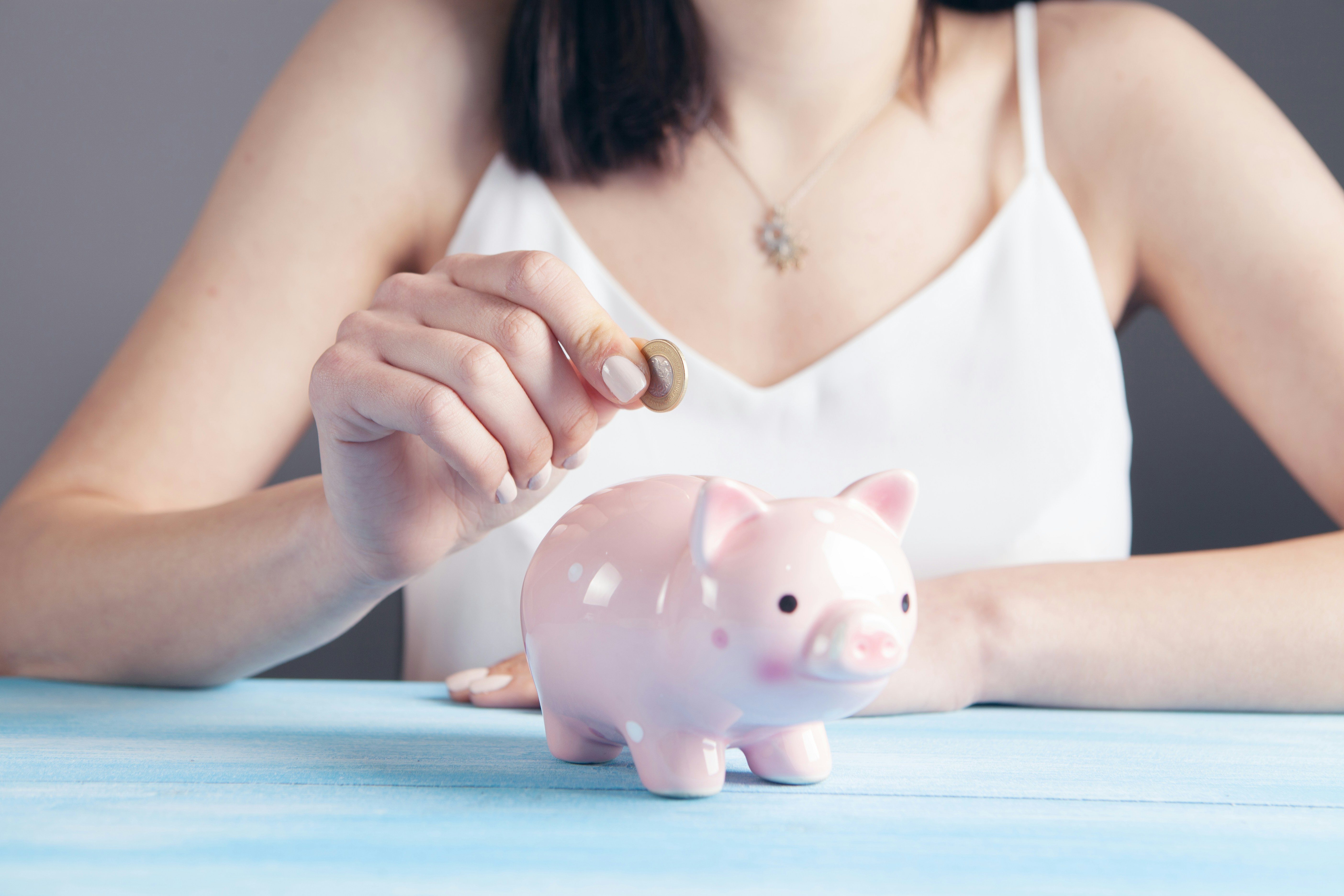 woman putting money into a piggy bang